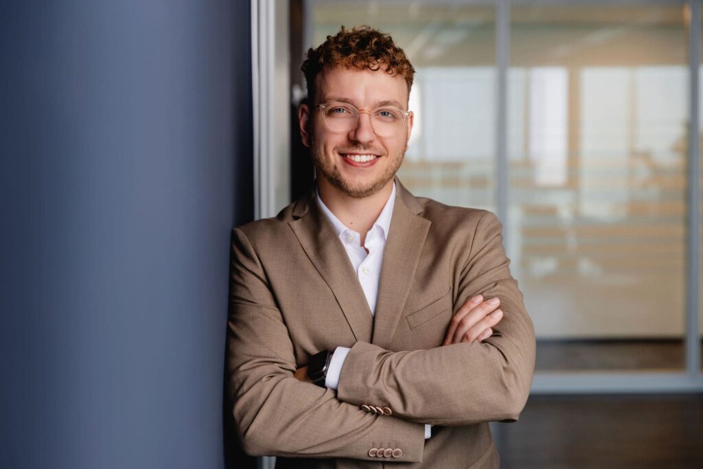Lockeres Portrait von Luca Popp, angelehnt an eine blaue Wand