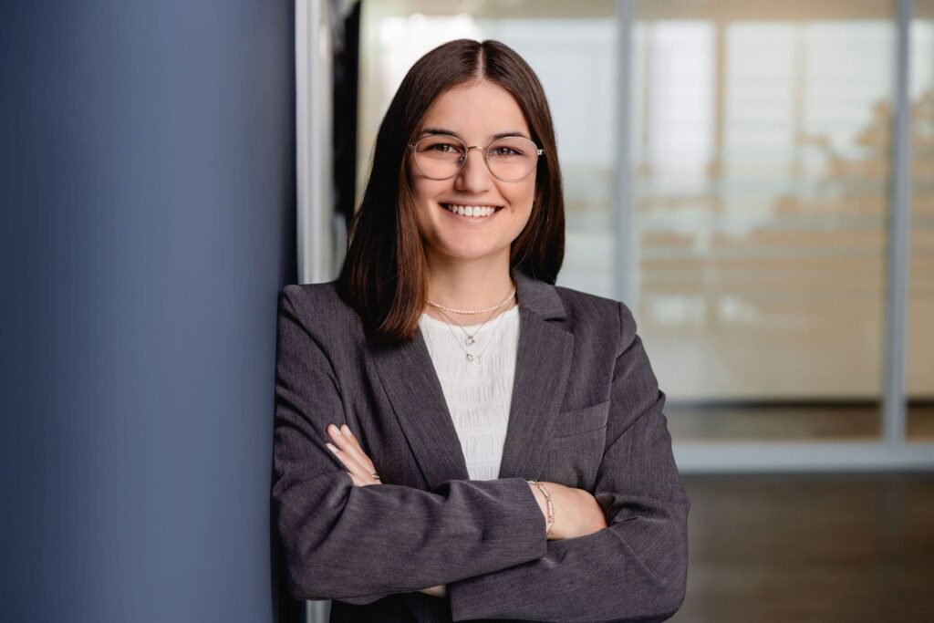 Lockeres Portrait von Dunja Sucic, angelehnt an einer blauen Wand
