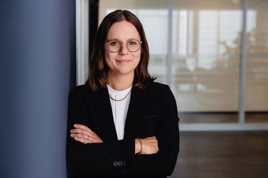 Lockeres Portrait von Marie Klara Thießies, angelehnt an einer blauen Wand