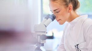 Eine Frau schaut in ein Mikroskop