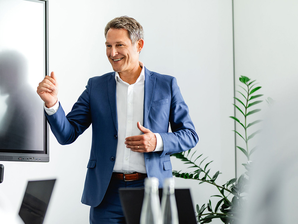 Mann in einem blauem Anzug präsentiert eine Lösung